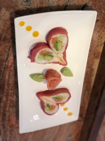 Heart-shaped tuna rolls presented with ginger and decorative leaves