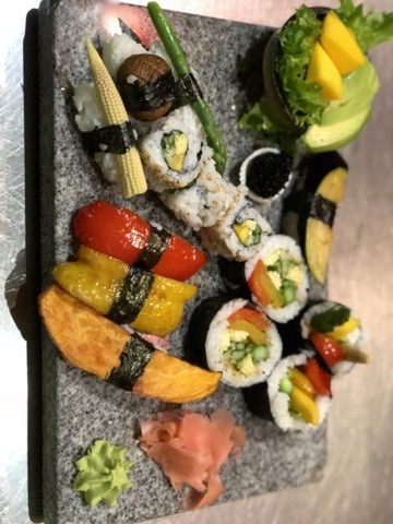 A colourful platter of vegetable rolls, nigiri and garnishes