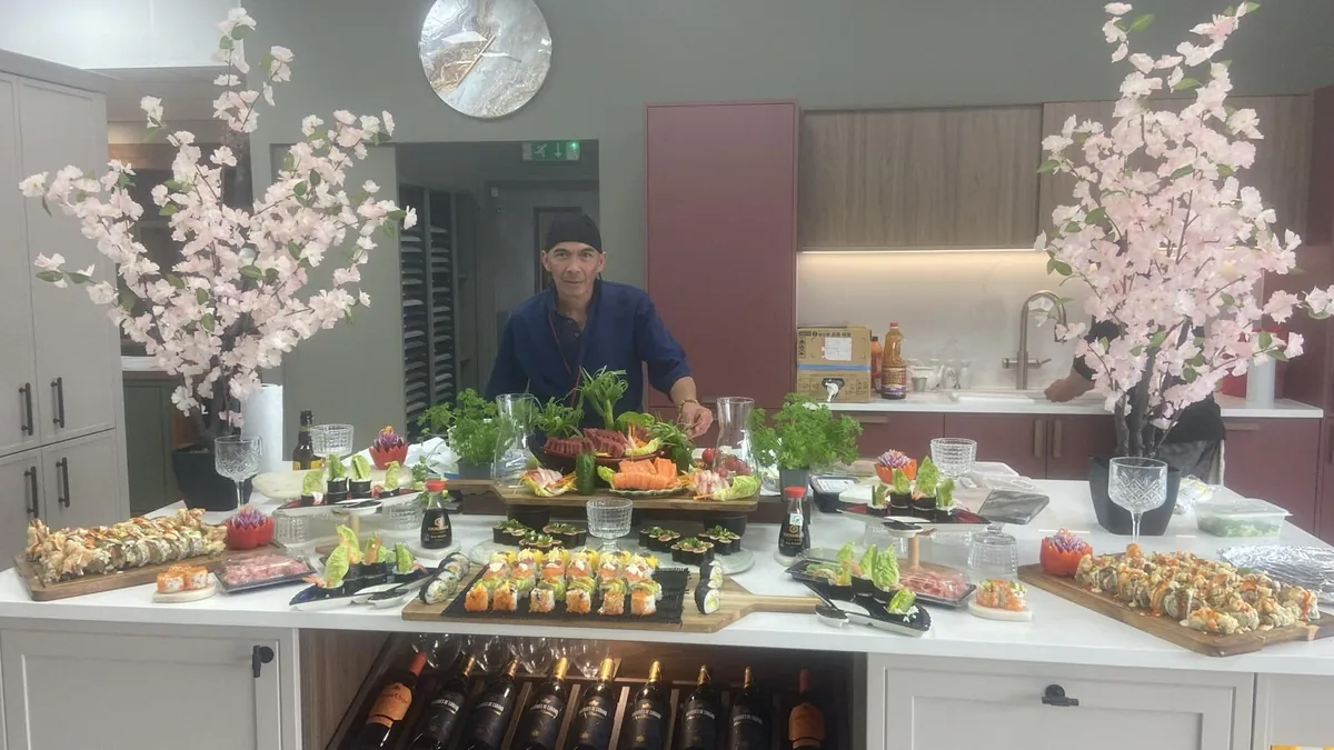 Chef Cisco behind a completed display of sushi, sashimi and garnished serving platters